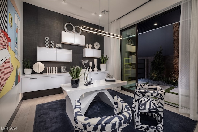 interior space with pendant lighting, light wood-type flooring, and white cabinetry