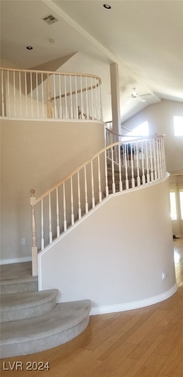 staircase with hardwood / wood-style floors, ceiling fan, and vaulted ceiling