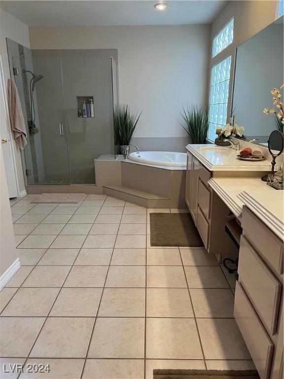 bathroom featuring tile patterned flooring, vanity, and shower with separate bathtub