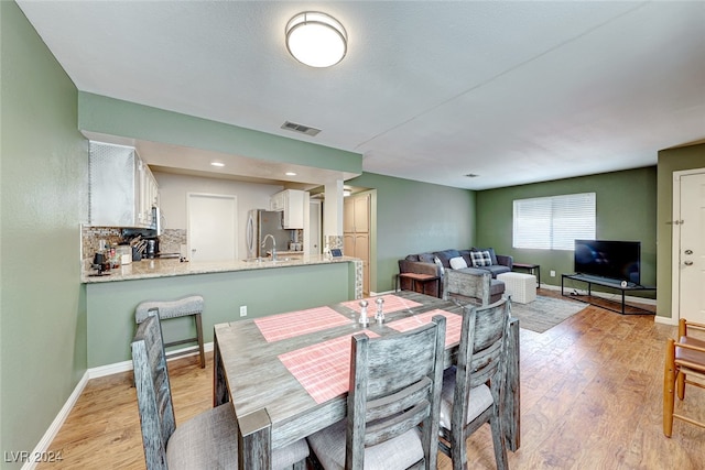 dining area with sink and light hardwood / wood-style flooring