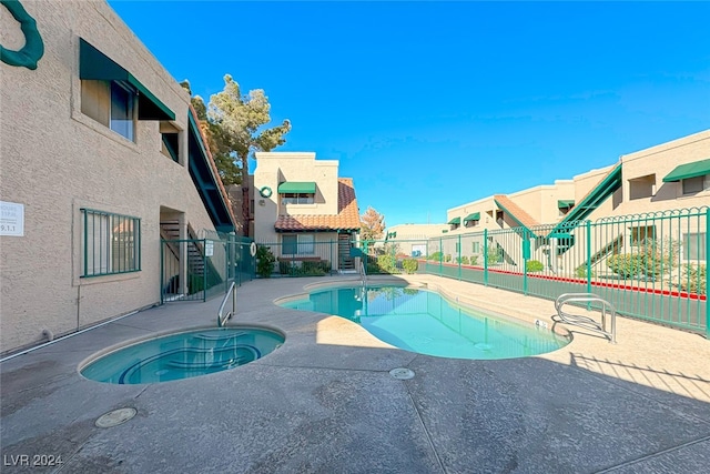 view of swimming pool with a hot tub