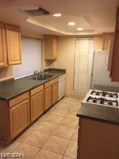 kitchen featuring sink, light tile patterned flooring, and white appliances