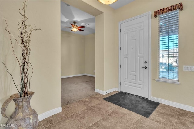 carpeted foyer entrance with ceiling fan