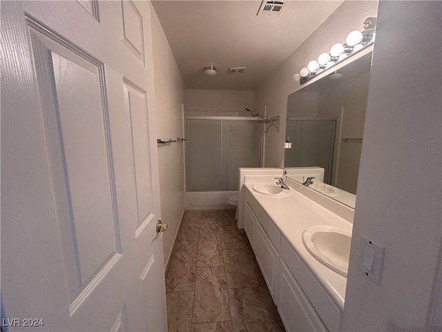 full bathroom with vanity, toilet, and shower / bath combination with glass door