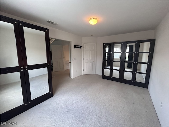 carpeted spare room with french doors