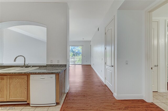 kitchen with dishwasher, light brown cabinets, light hardwood / wood-style flooring, and sink