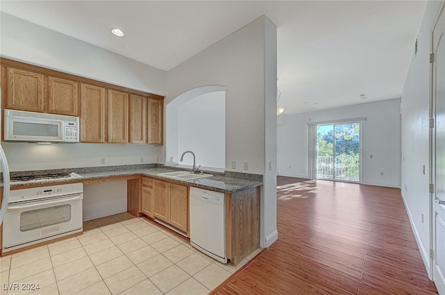 kitchen with light hardwood / wood-style floors, white appliances, and sink