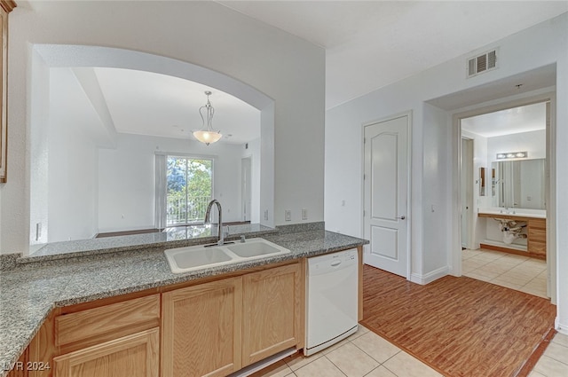 kitchen featuring light tile patterned floors, white dishwasher, light brown cabinetry, and sink