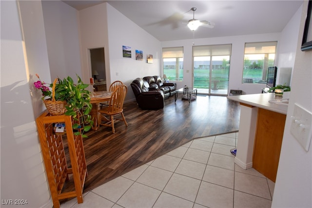 living room featuring light wood-type flooring, vaulted ceiling, ceiling fan, and a healthy amount of sunlight