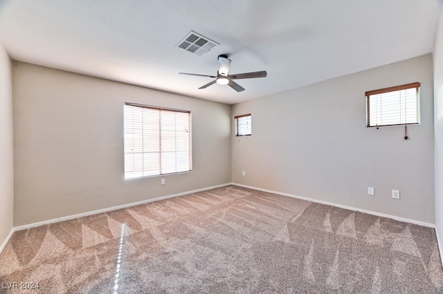 spare room with ceiling fan and carpet