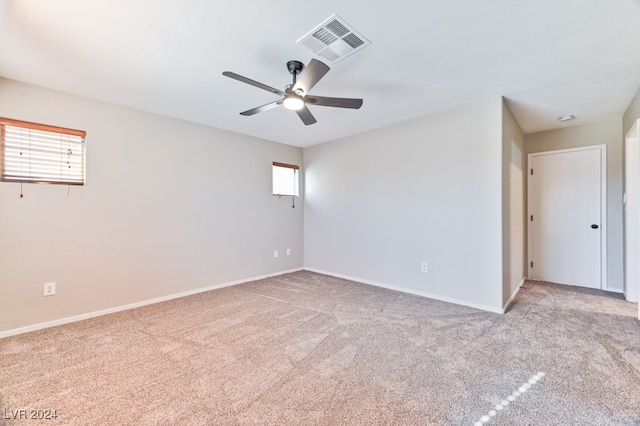 carpeted spare room featuring ceiling fan