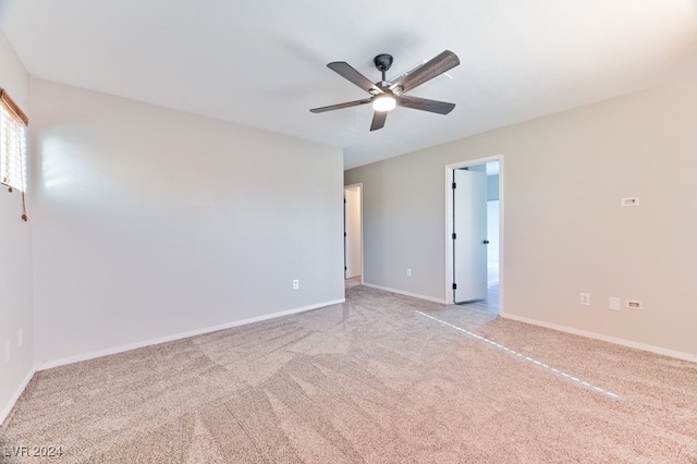 spare room with ceiling fan and light colored carpet