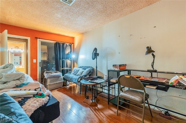 bedroom with hardwood / wood-style floors and a textured ceiling