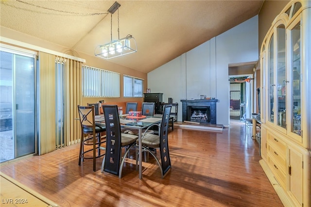 dining space featuring vaulted ceiling and dark hardwood / wood-style floors