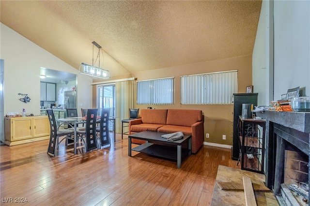 living room with lofted ceiling, wood-type flooring, and a textured ceiling