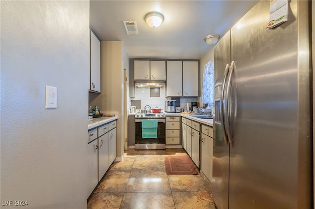 kitchen featuring appliances with stainless steel finishes, gray cabinets, sink, and backsplash