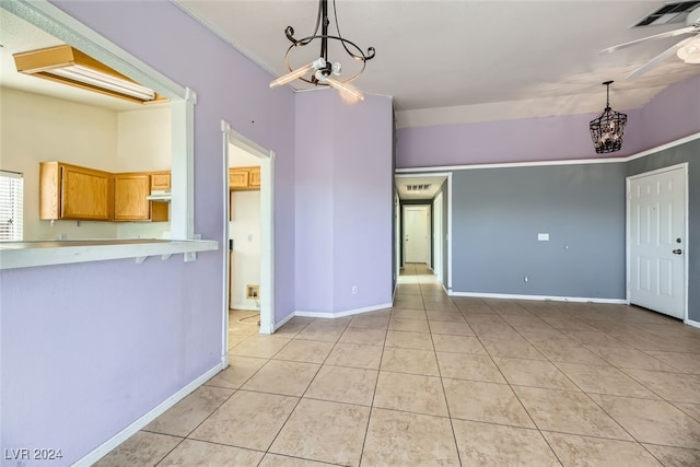 interior space featuring ceiling fan with notable chandelier and light tile patterned floors