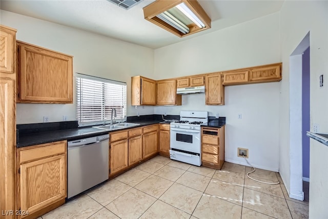 kitchen featuring stainless steel dishwasher, white gas range oven, sink, and light tile patterned floors