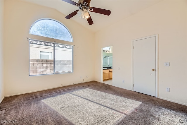 unfurnished bedroom featuring carpet, connected bathroom, high vaulted ceiling, and ceiling fan