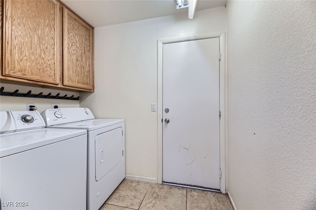 laundry area featuring separate washer and dryer, light tile patterned flooring, and cabinets