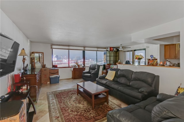 tiled living room with ceiling fan and a wealth of natural light