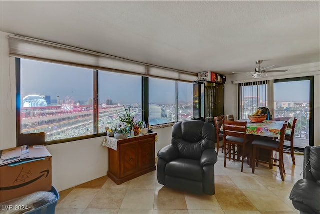 interior space with ceiling fan, a healthy amount of sunlight, and light tile patterned floors