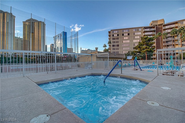 view of swimming pool featuring a hot tub