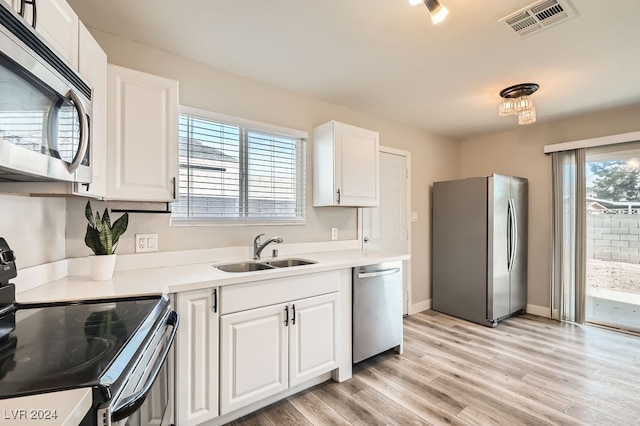 kitchen with white cabinets, appliances with stainless steel finishes, plenty of natural light, and sink