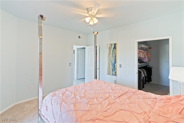 carpeted bedroom featuring ceiling fan, a spacious closet, and a closet