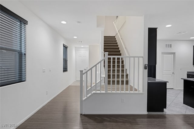 staircase featuring a healthy amount of sunlight and hardwood / wood-style flooring