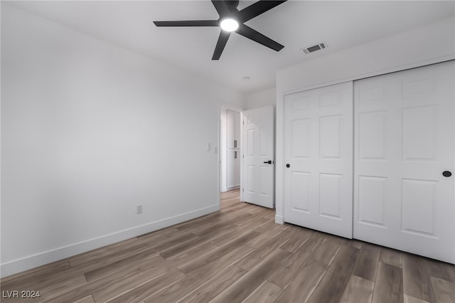 unfurnished bedroom with light wood-type flooring, a closet, and ceiling fan