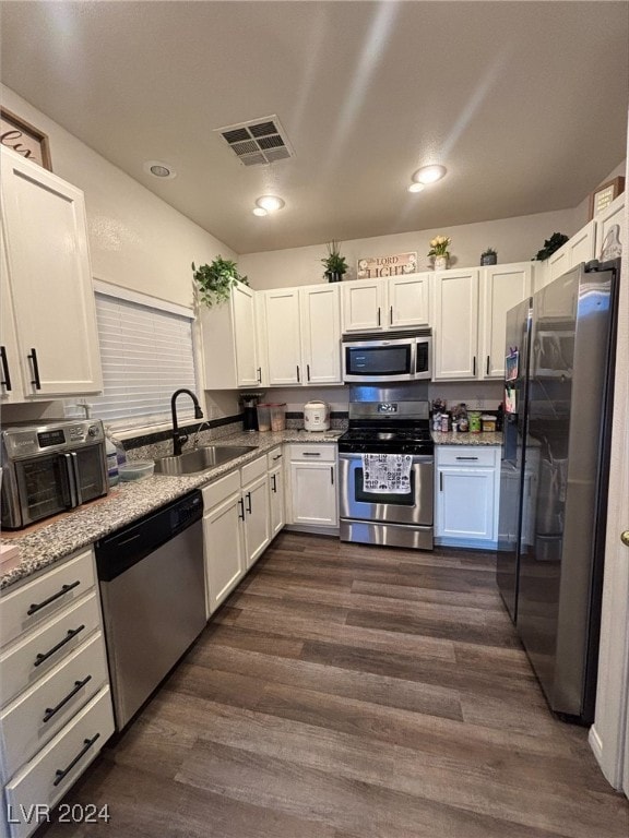 kitchen featuring stainless steel appliances, sink, white cabinets, and dark hardwood / wood-style floors