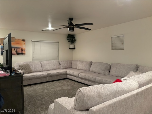 living room featuring ceiling fan and dark colored carpet