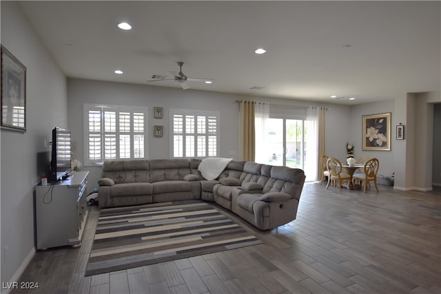 living room with dark hardwood / wood-style flooring, plenty of natural light, and ceiling fan