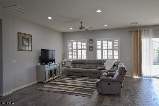 living room with dark hardwood / wood-style flooring and ceiling fan