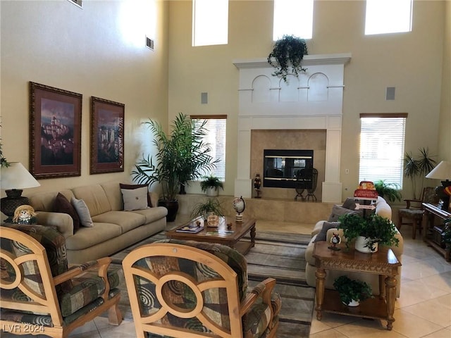 tiled living room with a towering ceiling and a high end fireplace