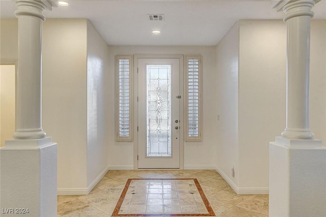 entrance foyer featuring light tile patterned floors and ornate columns