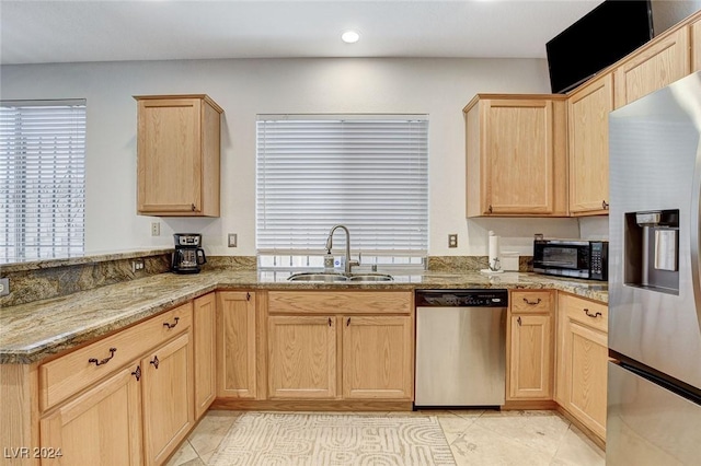 kitchen featuring light brown cabinetry, sink, light stone counters, and appliances with stainless steel finishes