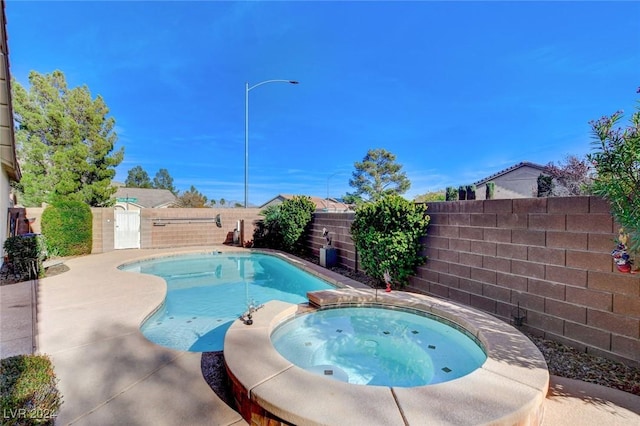 view of swimming pool featuring an in ground hot tub