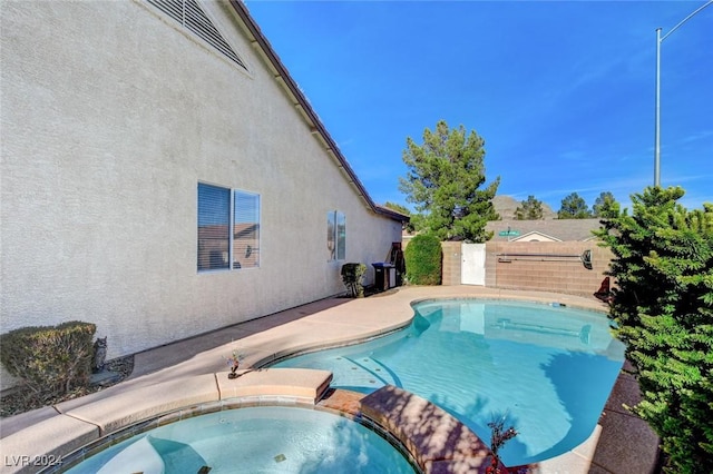 view of swimming pool featuring an in ground hot tub