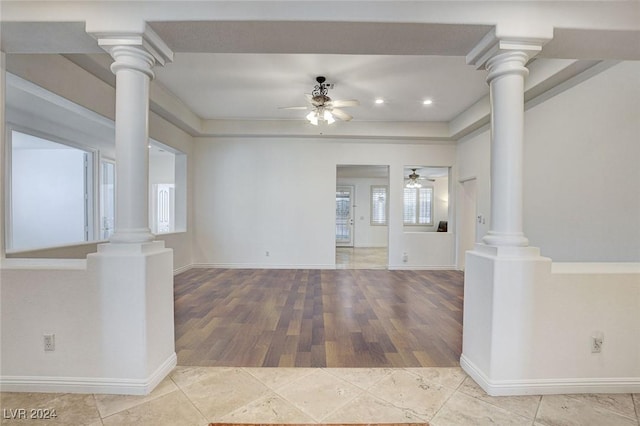 unfurnished living room featuring decorative columns and ceiling fan