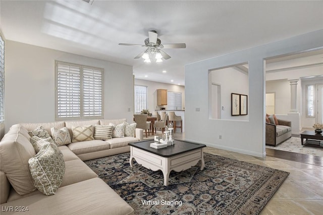 tiled living room with ceiling fan and decorative columns