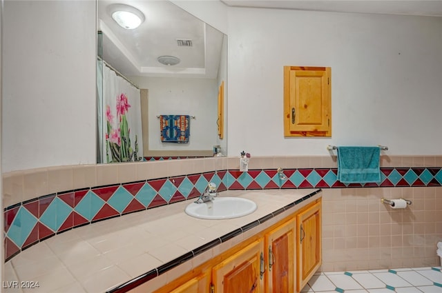 bathroom featuring tile patterned flooring, vanity, and tile walls