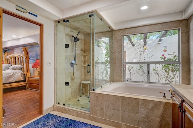 bathroom featuring wood-type flooring, vanity, and shower with separate bathtub