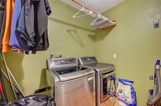 clothes washing area featuring washer and dryer and a textured ceiling