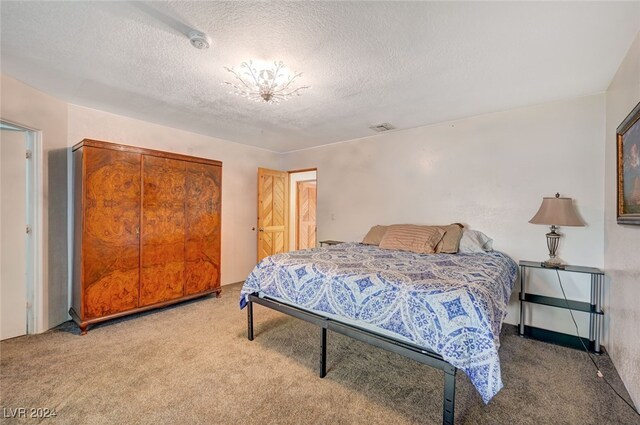 bedroom with carpet floors and a textured ceiling