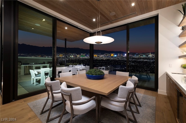 dining room with light wood-type flooring and wooden ceiling