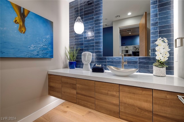 bathroom with tasteful backsplash, vanity, and hardwood / wood-style flooring