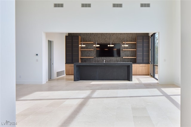 unfurnished living room with a high ceiling