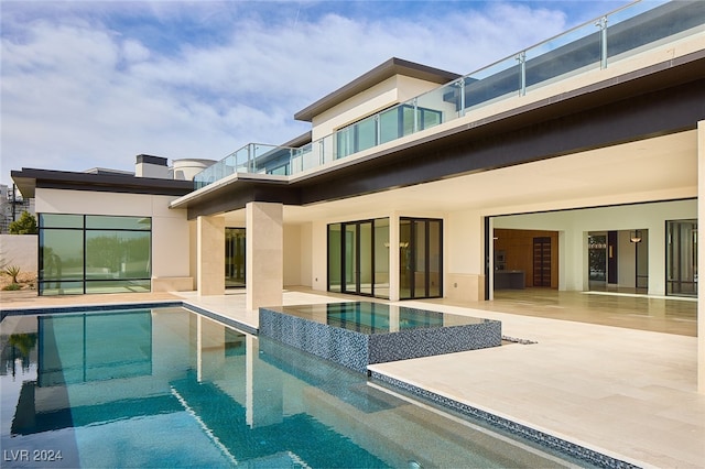 rear view of property with a patio area and a balcony